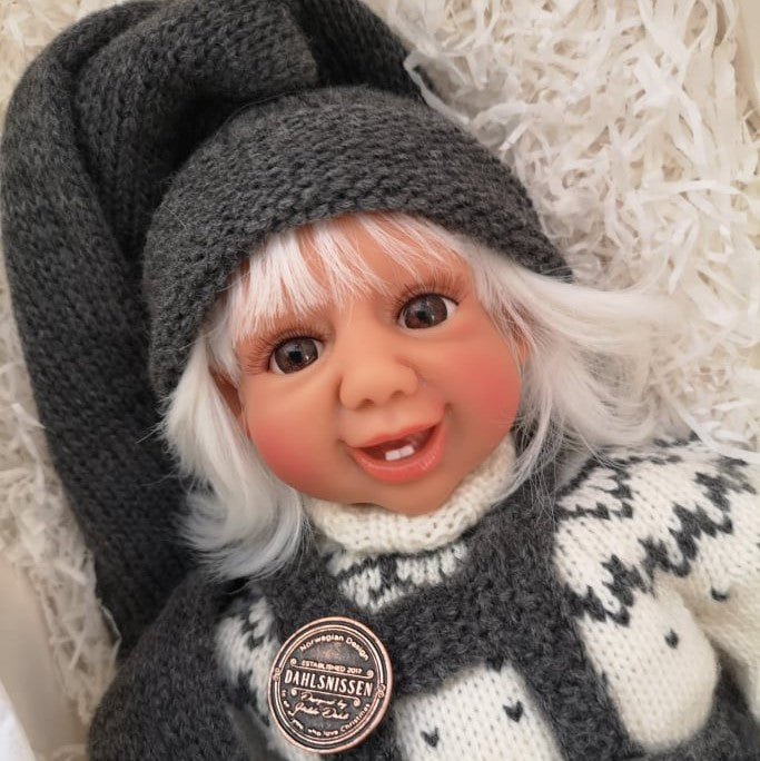 Fjøsnissen kommer med hvitt hår i tidløse mørk grå nisse klær. Dahlsnissene finnes med blå, brune eller grønne øyner. Nostalgiske og tidløse nisser. Designet av Hilde Dahl.